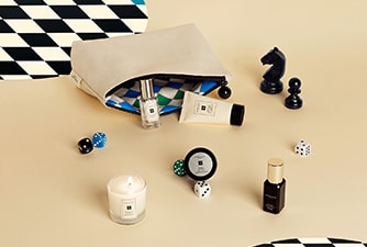 Launch image of advent calendar dartboard box shown open with examples of 5 product contents on checkerboard background.