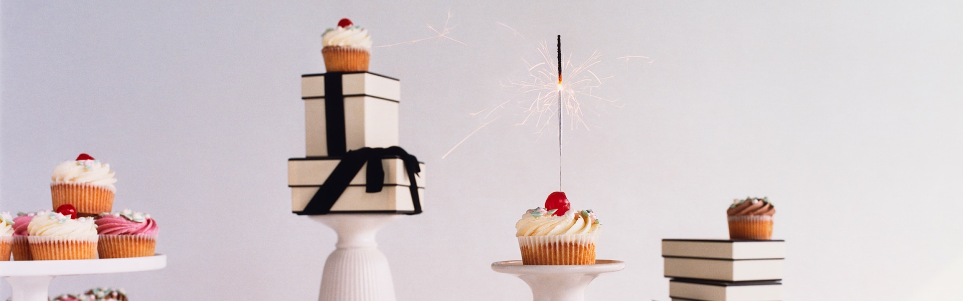 birthday cake & a pair of hands in satin green gloves holding jo malone gift bags, gift boxes, candle and diffuser